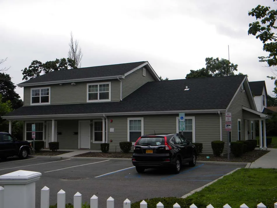 Residential building with Honda SUV in parking space.